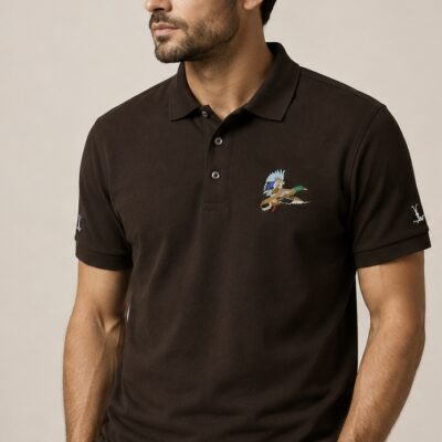 Polo castanho com pato-real no peito e logotipo Cor do Monte nas mangas